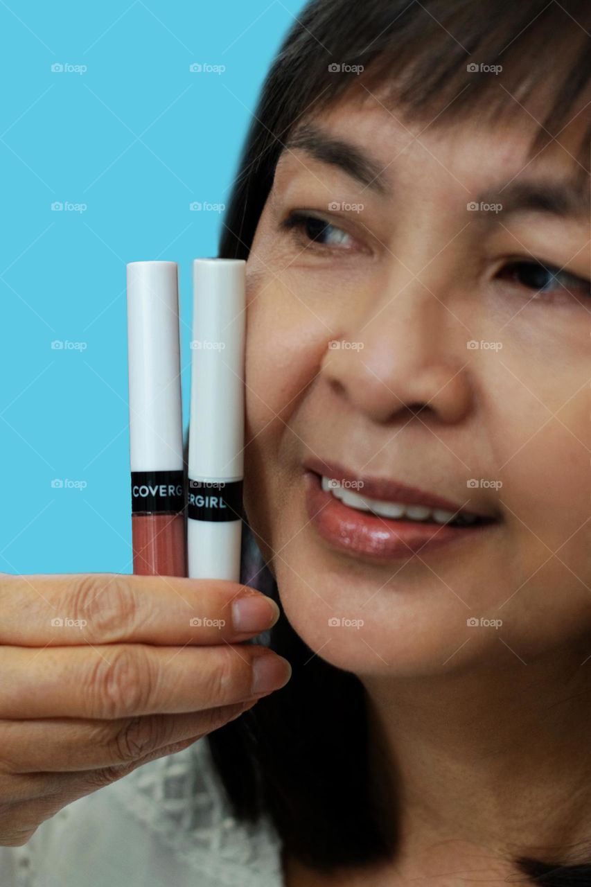 Close-up shot of a woman holding lipsticks