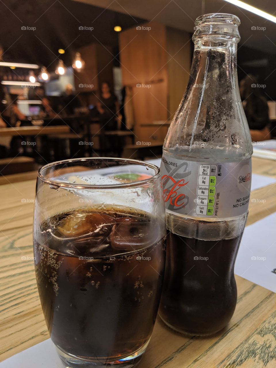 a glass of coke and the bottle it was poured from