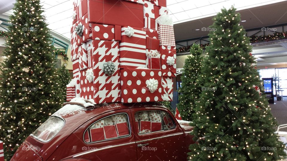 red car covered in Christmas presents with trees