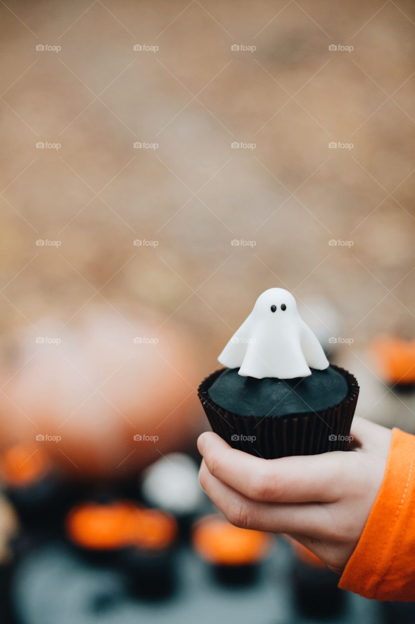 Close-up of hand holding halloween cupcake