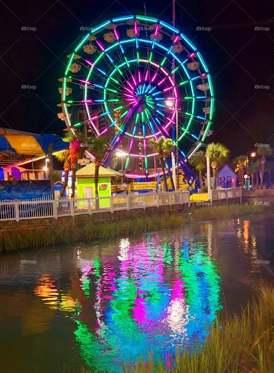 Colorful Ferris Wheel with reflection on water