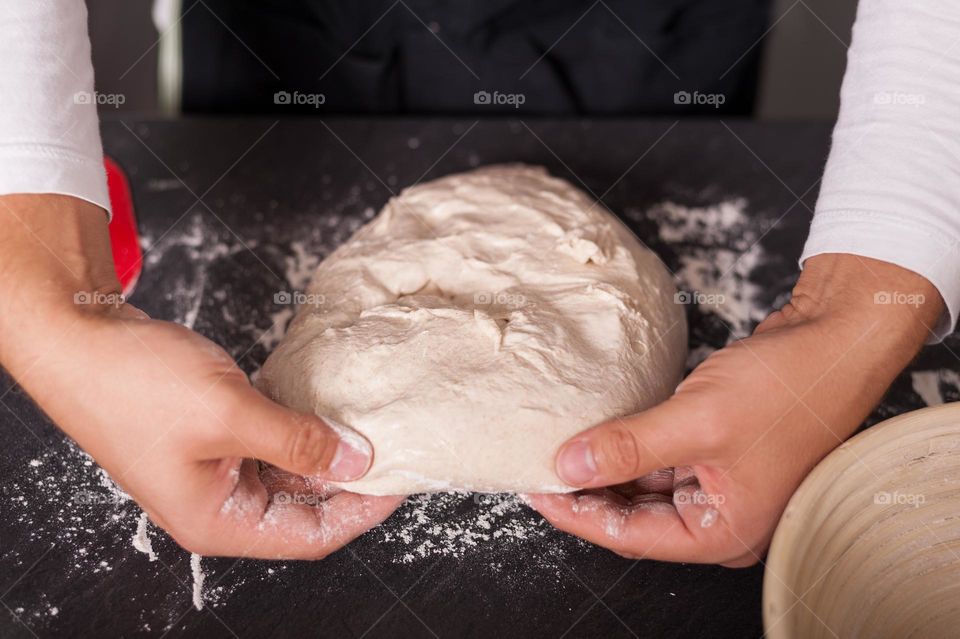 Folding and kneading dough to proof and release air bubbles. Baking bread at home.