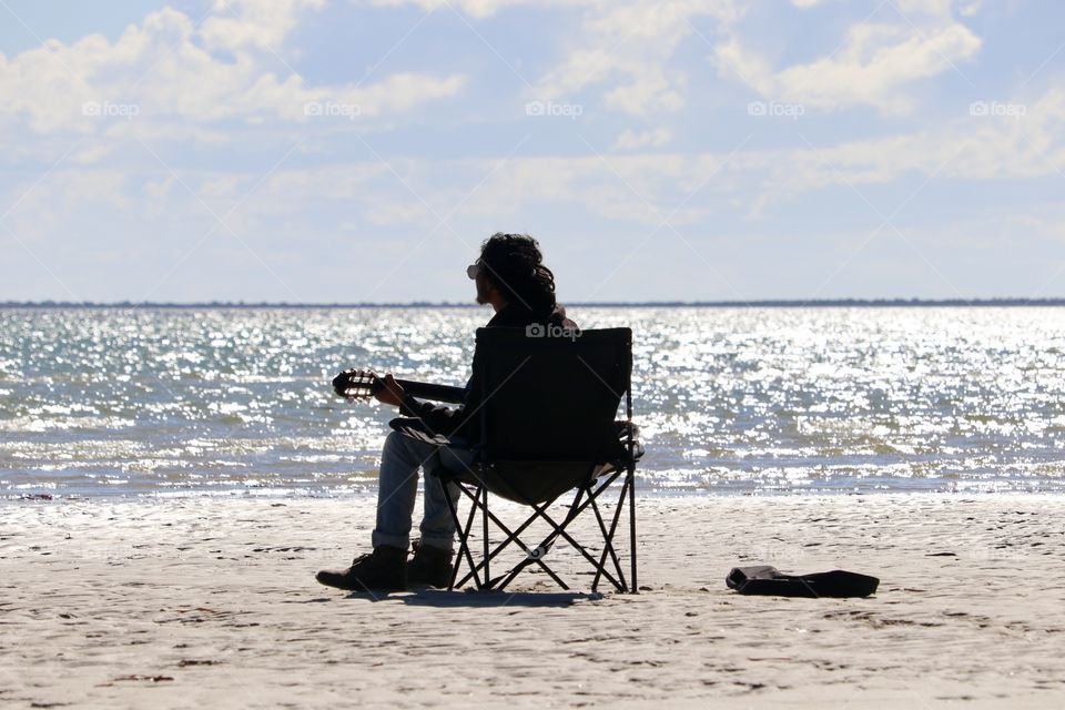 Dreamer; lone guitarist singer on beach 