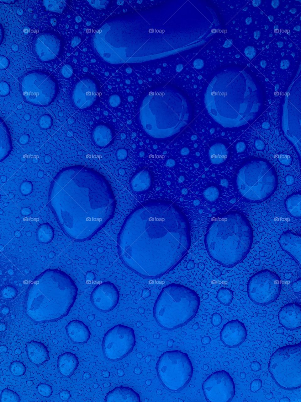 blue surface wet with water with large drops highlighted to form a texture