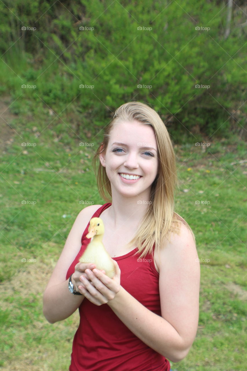 Blonde girl holding little baby duckling