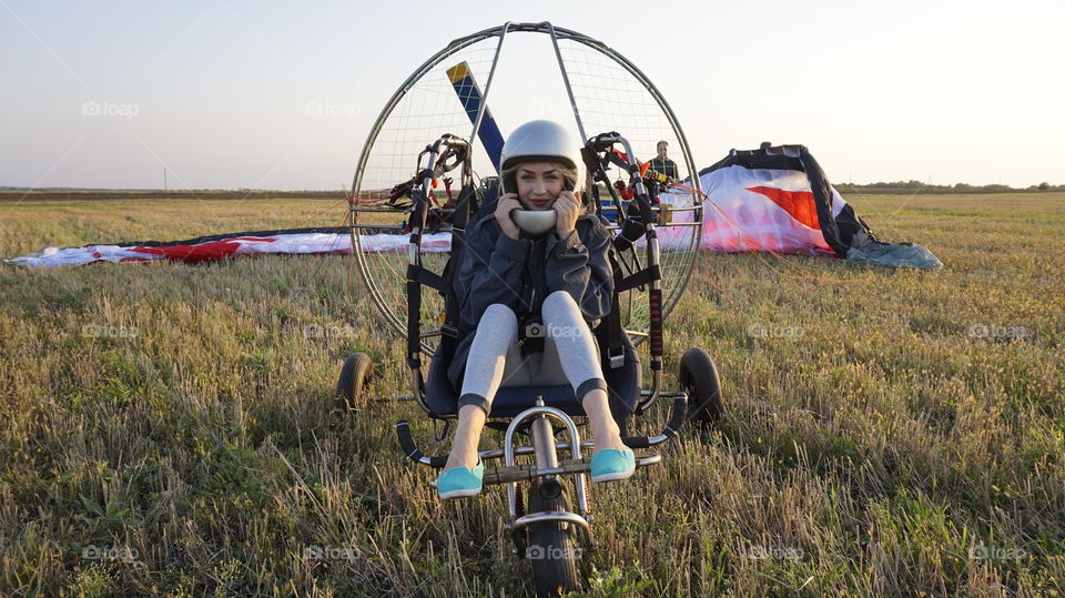 Young woman sitting on vehicle wearing helmet