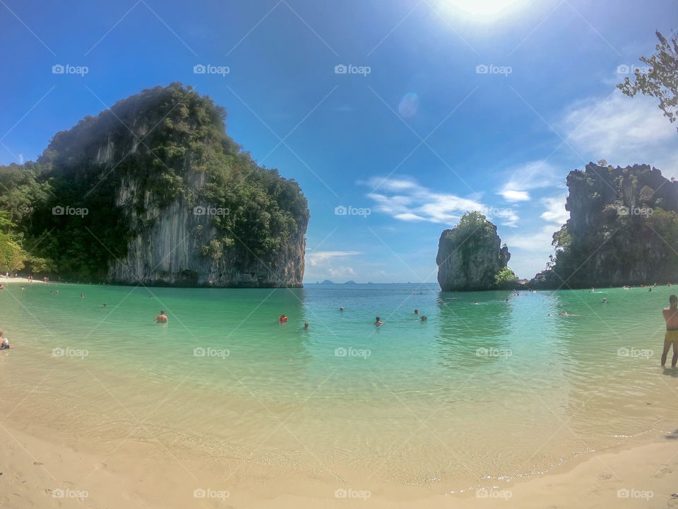 Paradisíaca playa de Tailandia donde podemos ver una gama de colores verdes y azules en sus aguas cristalinas acompañado de un fondo rocoso y vegetación exuberante