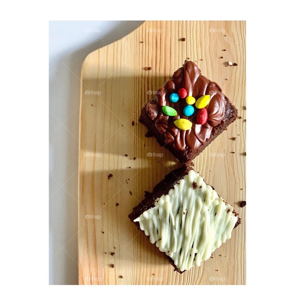 Home baked brownies in white chocolate drizzle and M&Ms sprinkles 