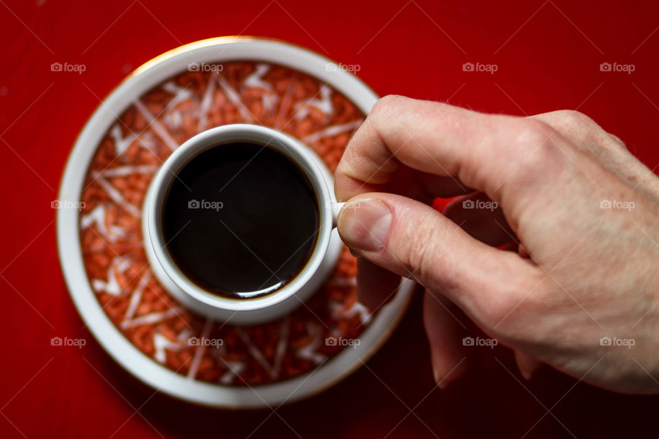 Hand is holding cup with coffee