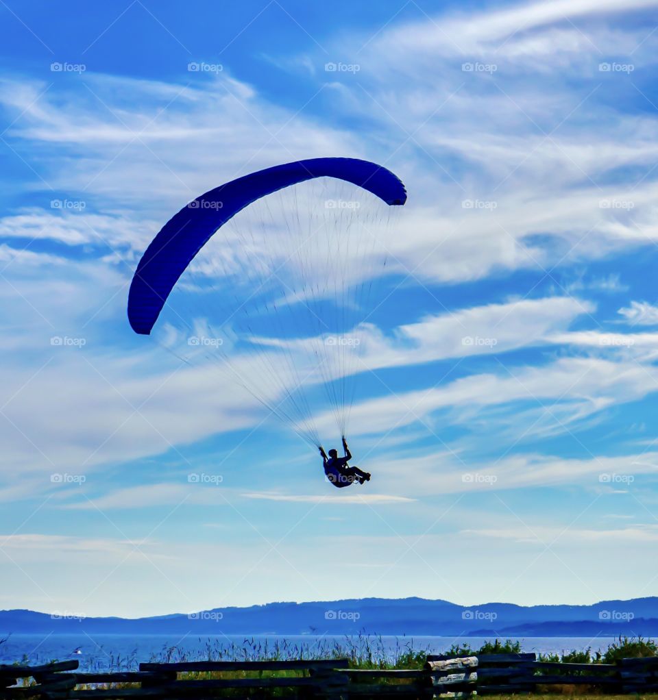Paragliding into the clouds over a scenic ocean 