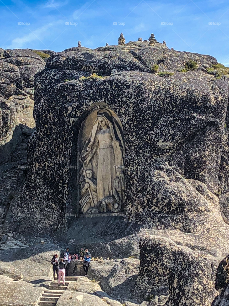 People look tiny in comparison to Senhora da Boa Estrela, a sculpture carved from the stone