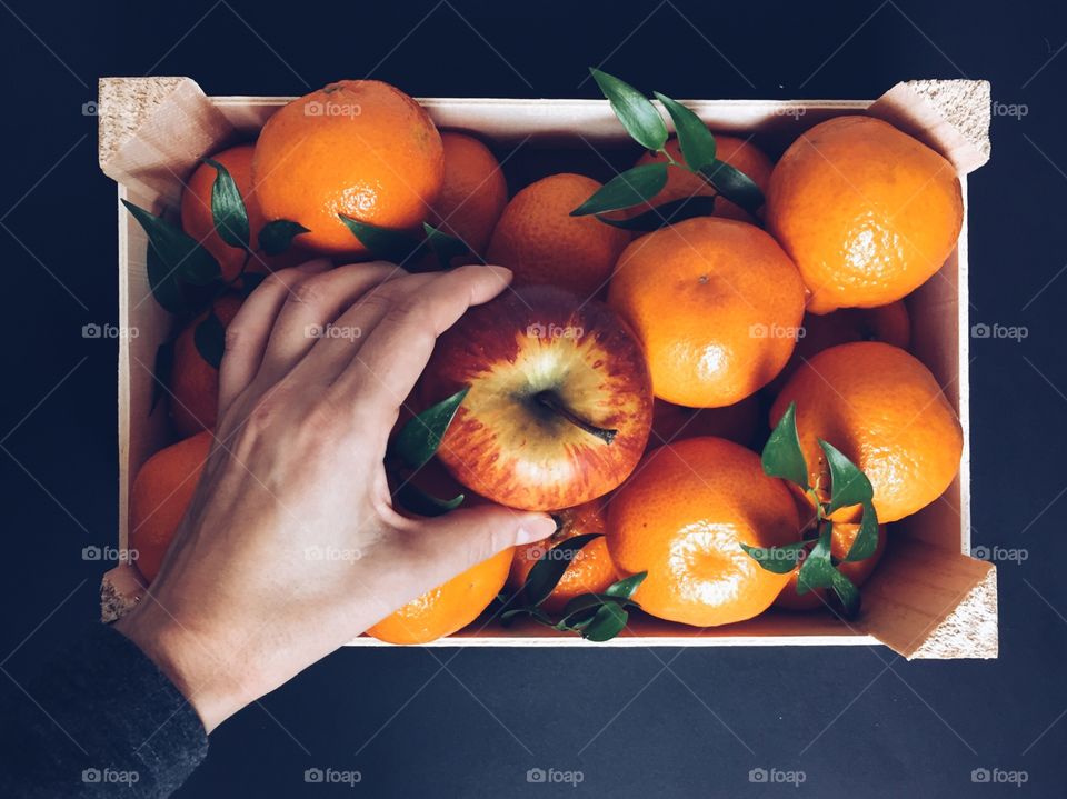 Woman hand taking apple from fruit basket