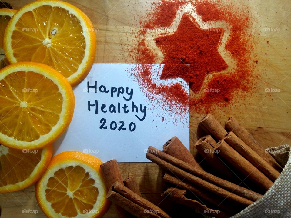 Happy new year 2020! Wishing you a happy healthy 2020. Image with spice star orange cinnamon sticks and handwritten note