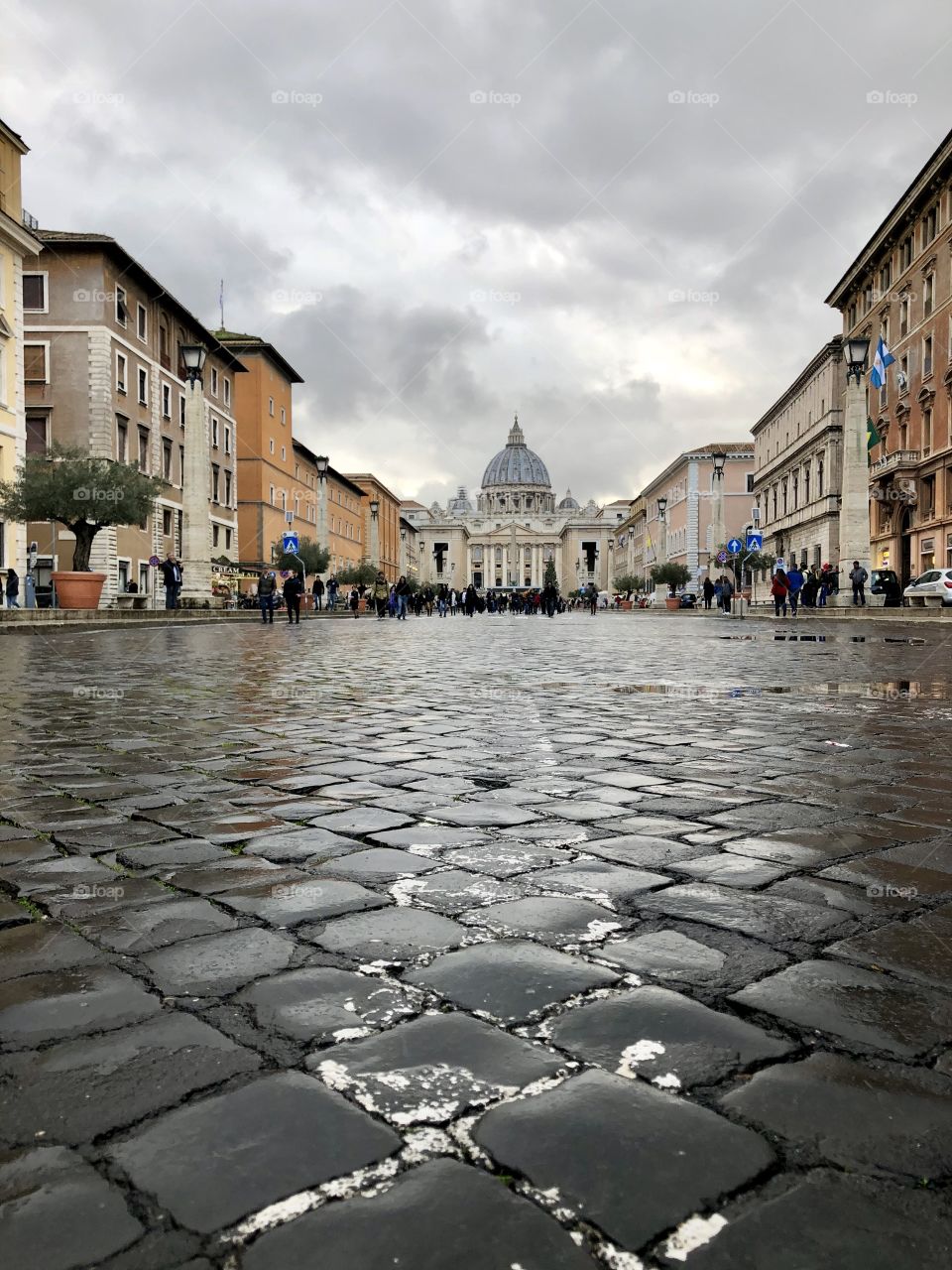Wet, faded, cobblestone road to the Vatican City. St Peters is pictured at the end of the road.