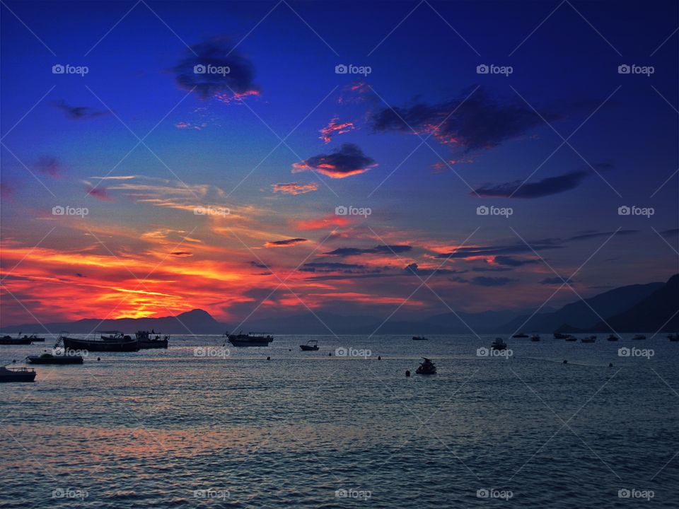 Silhouette of boat over the idyllic sea at sunset