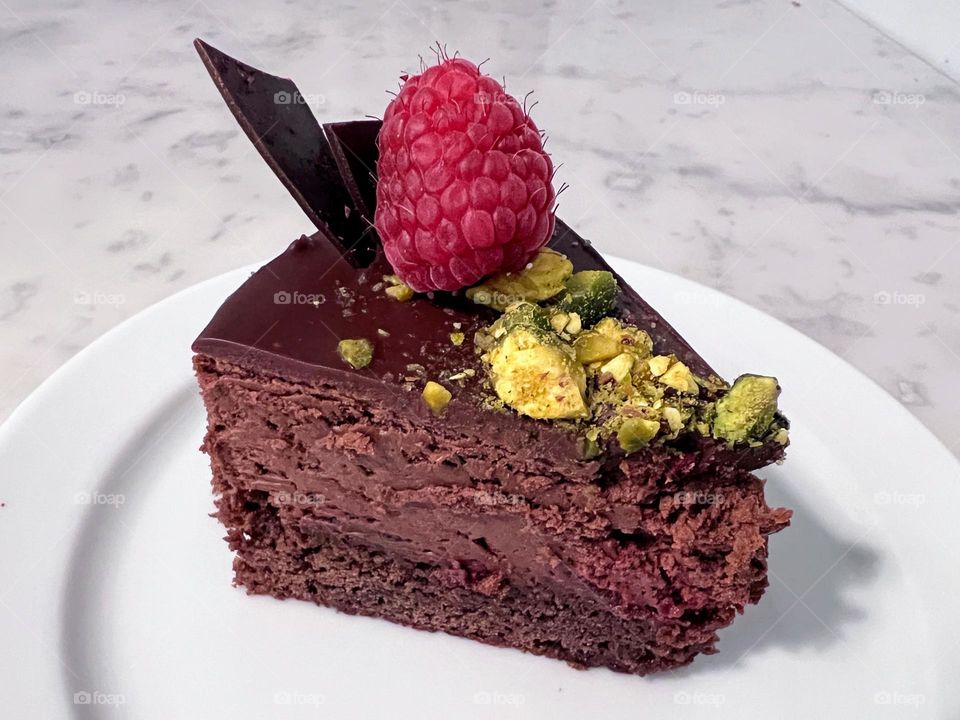 Close up of yummy dessert, chocolate, pistachio, raspberry cake