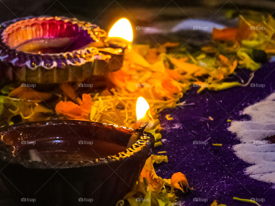 Burning Diya or earthen lamp with Rangoli and flower petals in Indian festival Diwali looking attractive.Decoration.