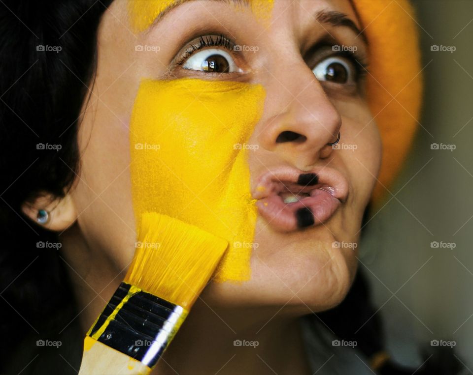 Funny face, positive emotions, portrait of a painter woman in yellow color