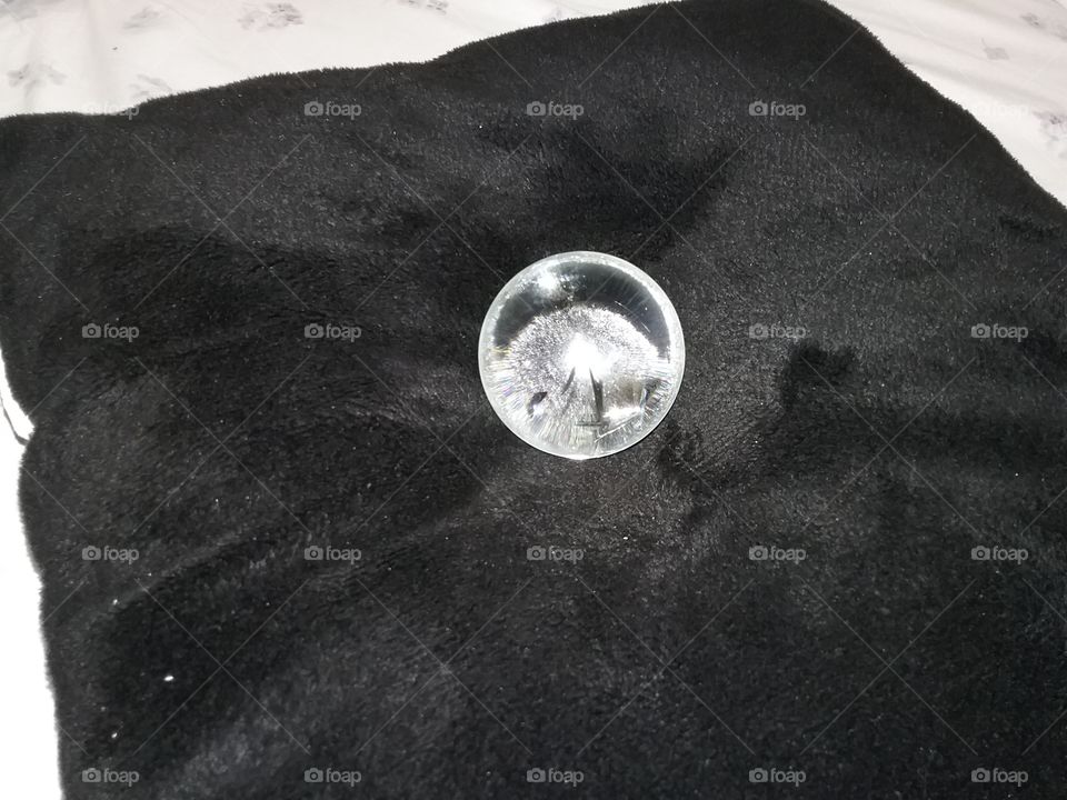 Glass orb on plush pillow.