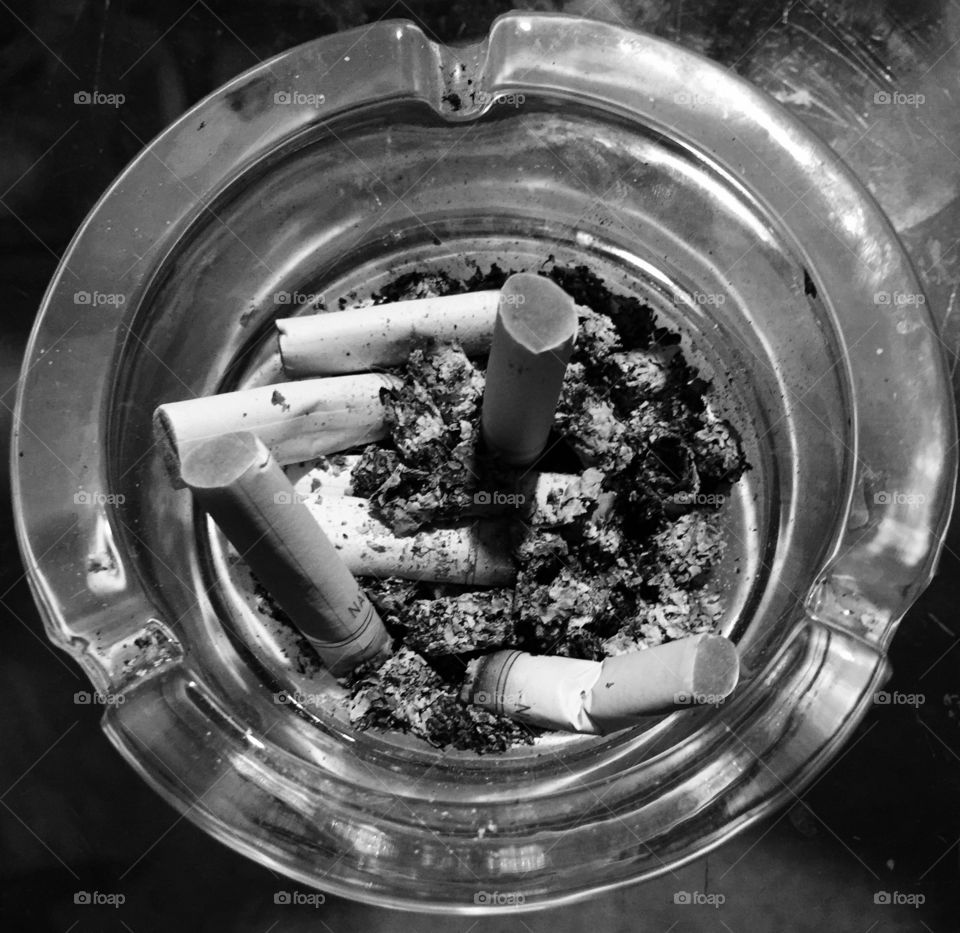 Black and white cigarettes in ashtray.