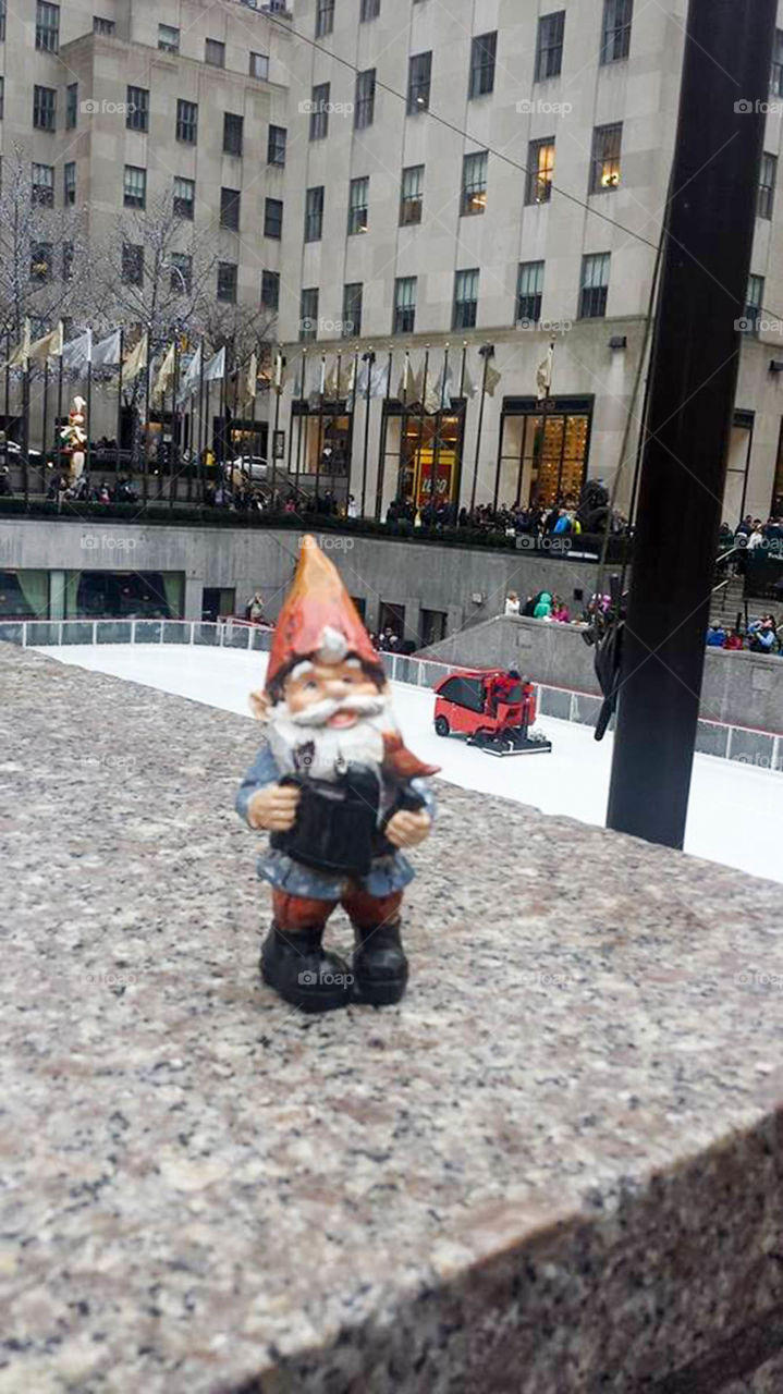 Gnome in NYC. Gnome watches the ice skaters at Rockefeller Center in New York City