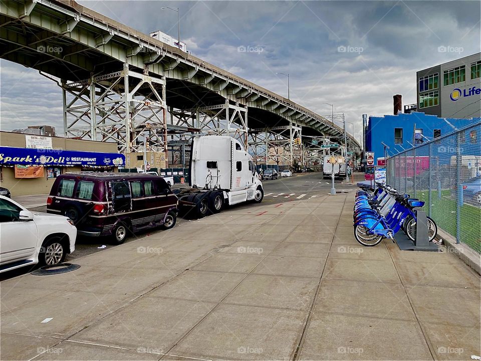 It is modern architecture par excellence at “Hunters Point” in LIC, Queens. The “Brooklyn Queens Expressway”, “BQE” overpass slopes downward into the distance running parallel to the “Borden Ave Bridge” over “Dutch Kills”. 2023. Hypnotic Productions