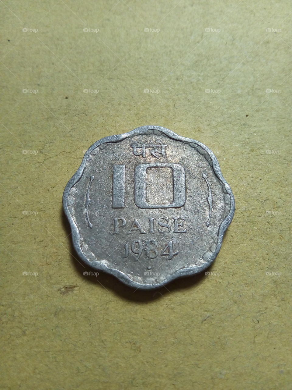 A coin of ten paise- 1/10 share of Indian Rupee issued by Government of India in 1984.