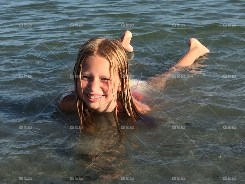 Little girl swimming in the ocean 