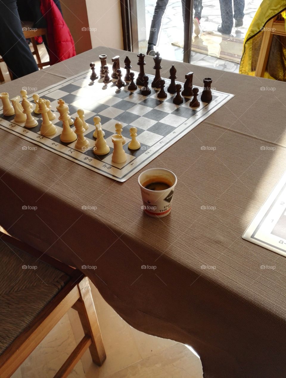 cup of take away espresso coffee on chess table