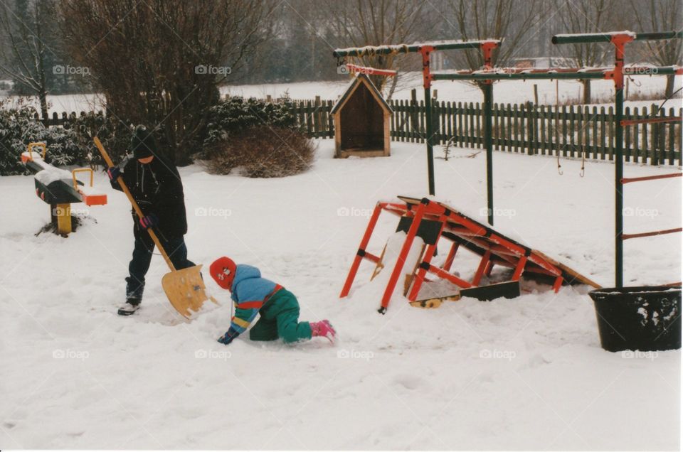 Kinder spielen im Schnee im Garten