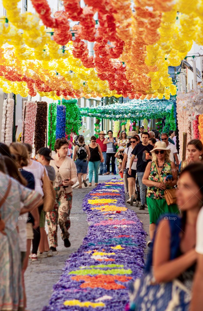 A busy, colourfully decorated street for a summer’s festival in the city of Tomar, Portugal