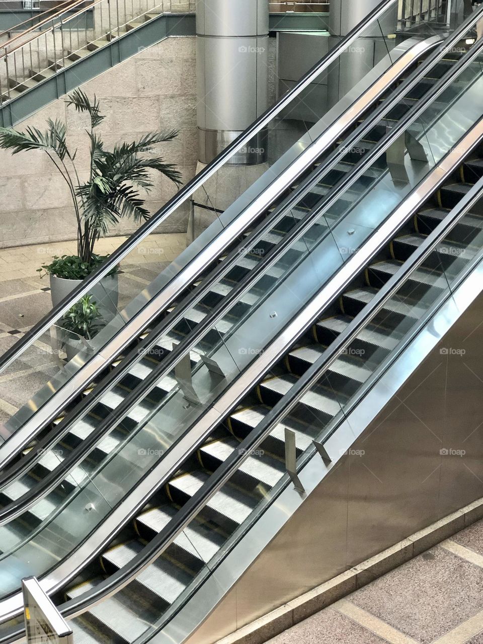 Escalators are essentially motorized staircases that are powered by electricity. An escalator features multiple steps in a row, ascending in succession at an incline. This was shot on iphone in South Station Bus Terminal in Boston. 