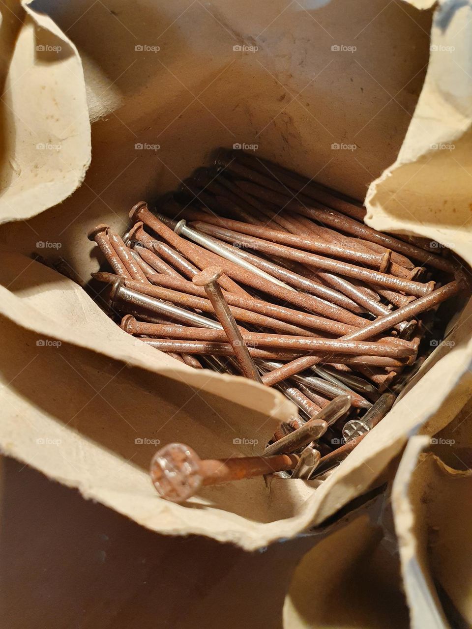 long rusty nails in a paper bag