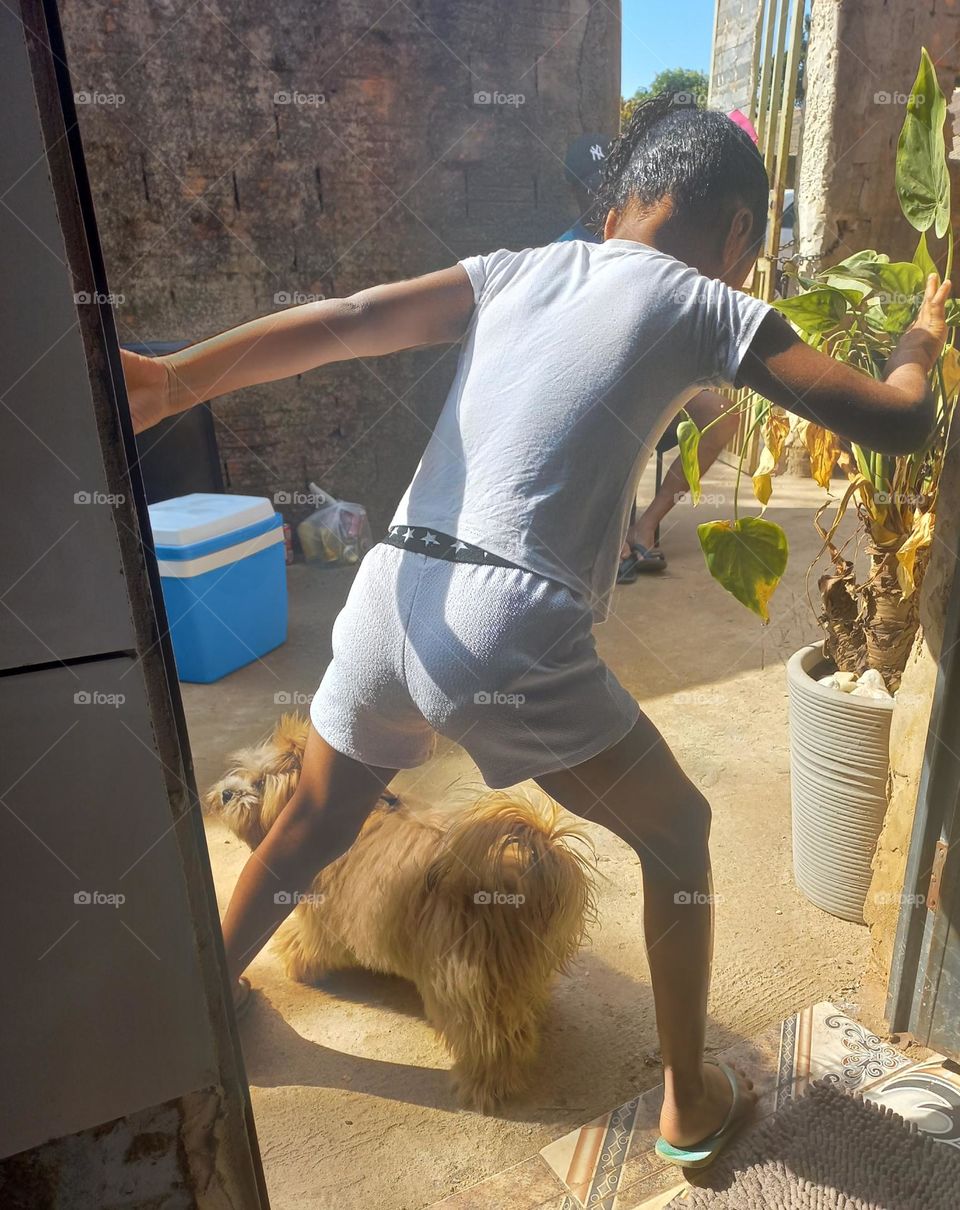 Criança  brincando  de pular com seu pet. O exercício  físico  é importante tanto para os seres humanos quanto para os animais de estimação, além de promover  o gasto de energia de ambos.  Isso aumenta a conexão  entre humanis e pets