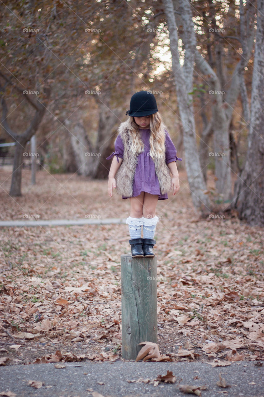 Balance. Child Balancing on a pole in the park in fall