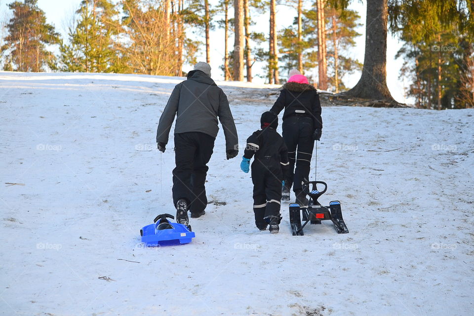 Family having fun outdoors sledding