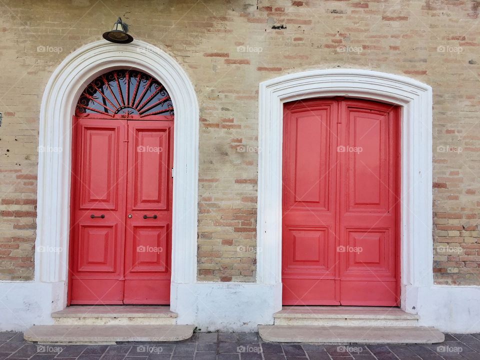 Vintage red painted doors on a bricked house