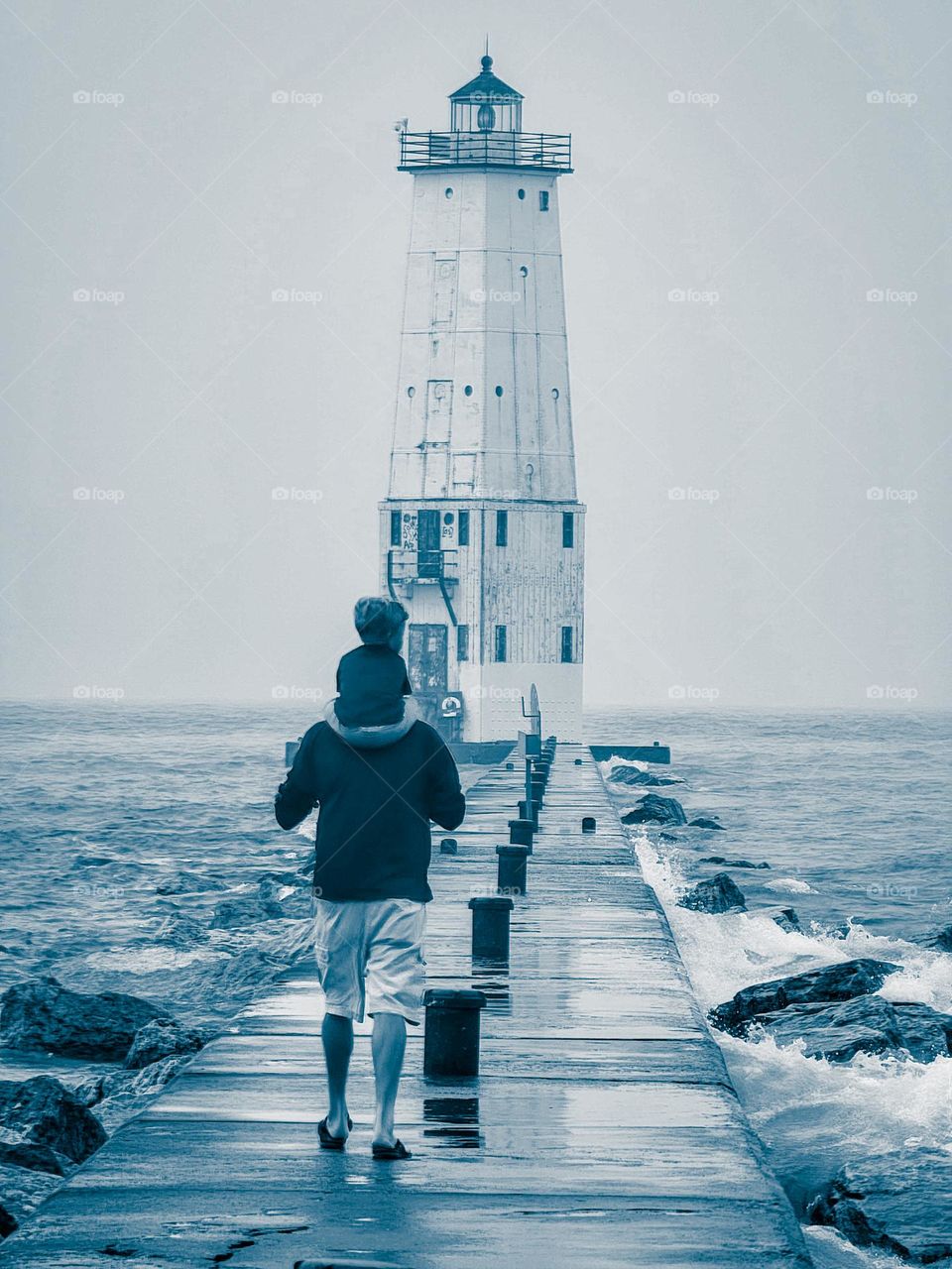 A papa's and grandson bond is amazingly beautiful. Walking out on a pier towards a lighthouse and enjoying the view.