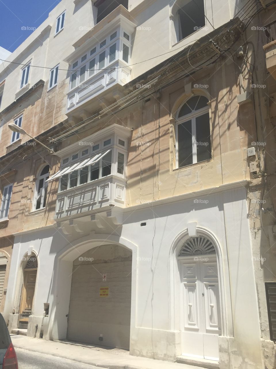 Windows around the World. A street scene in Malta showing the open windows of a traditional, enclosed, Maltese Balcony.