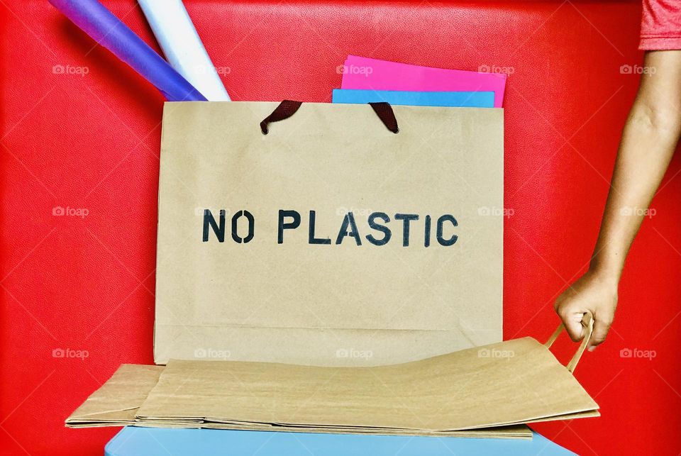 No plastic  on paper bag and one hand taking paper bag .