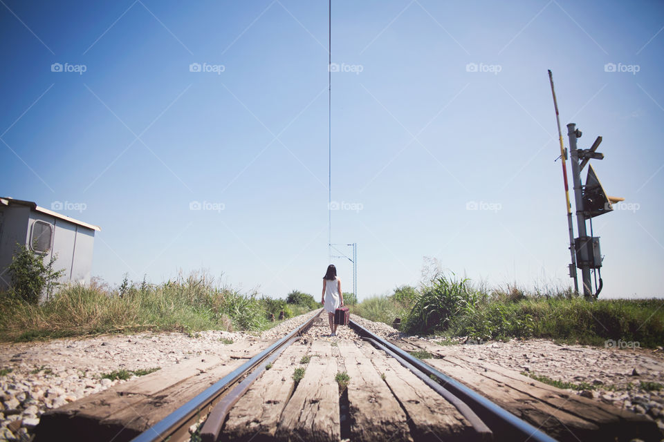 Rear view of woman walking on railtrack