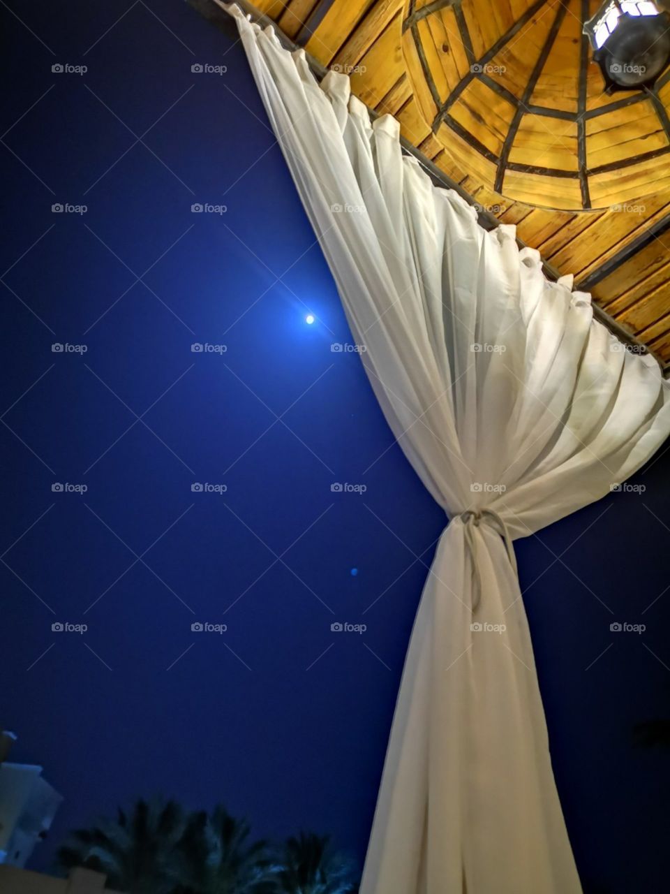 A beautiful view with curtain in front and very bright star on the sky in back