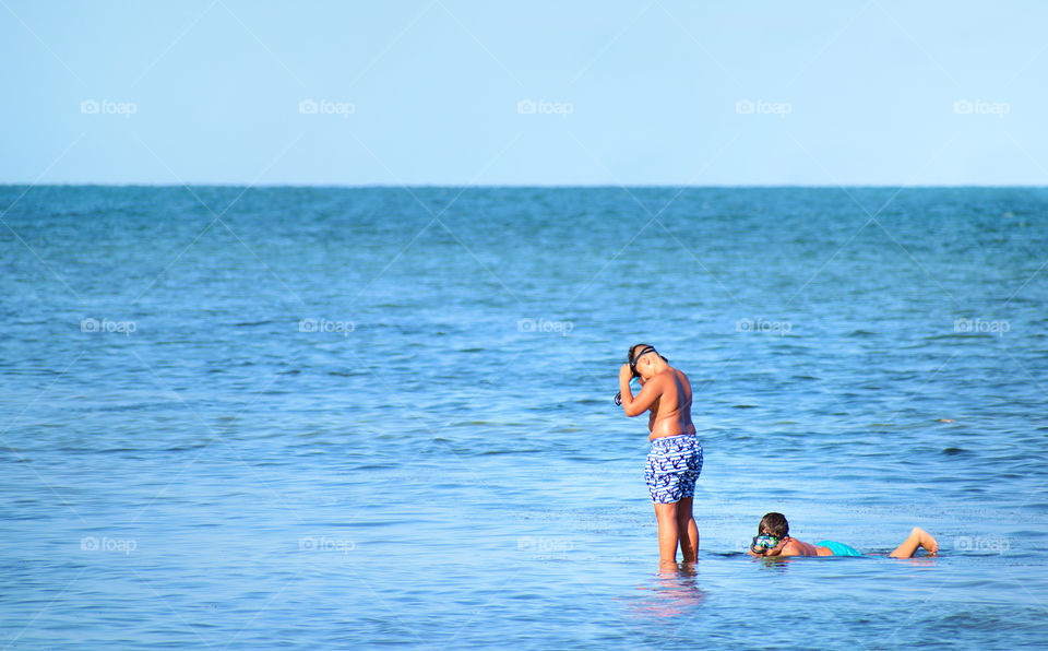 Two little boys snorkeling at the seashore