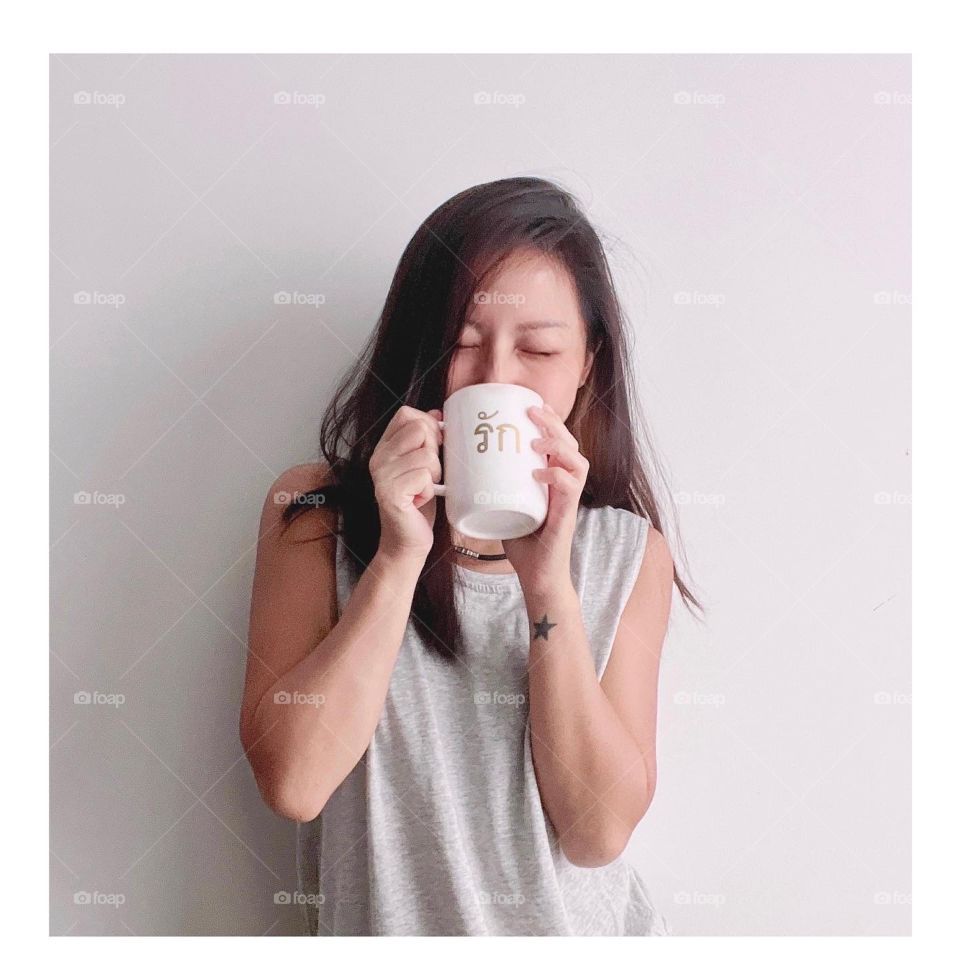 Asian woman in white mug with coffee 