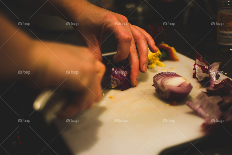 Close-up of hand chopping onion
