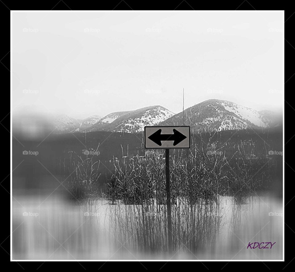 road sign in front of the rocky mountains during winter,  blurred edges