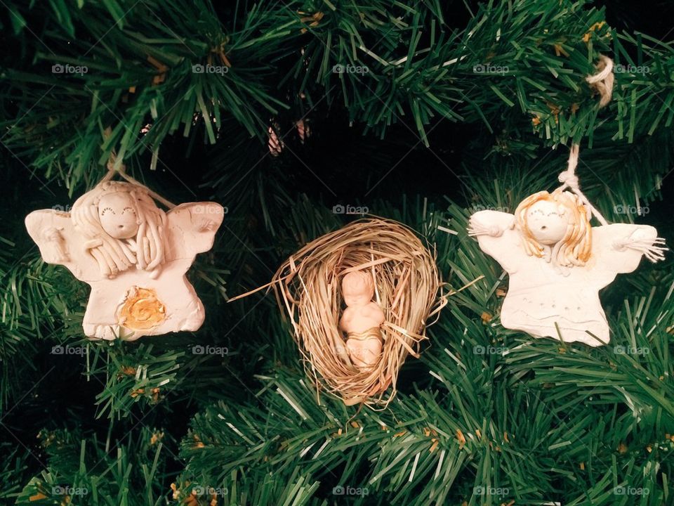 Little angels and Jesus figurine on christmas tree