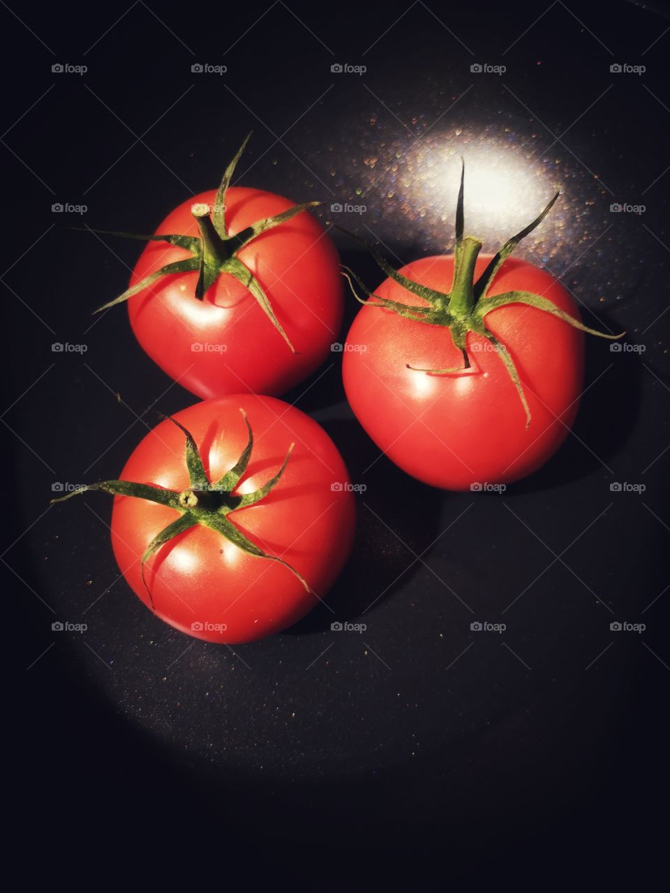 Red tomatoes on the black background