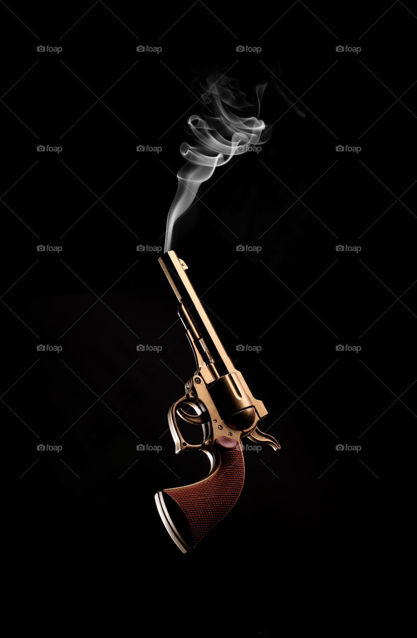 Vintage Golden Revolver Gun with smoke coming out