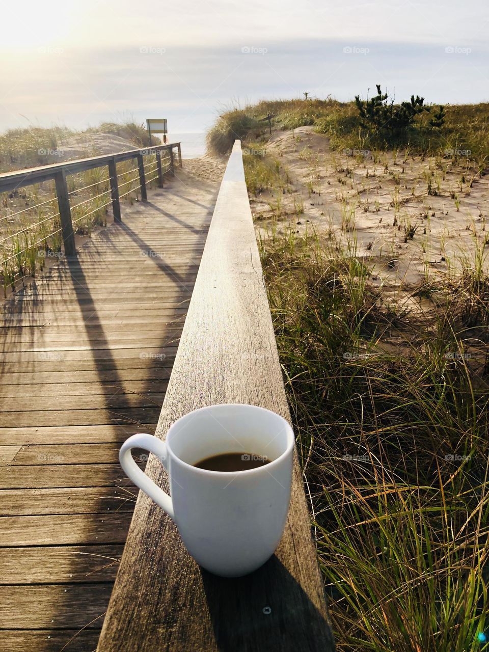 Coffee cup on wood railing 